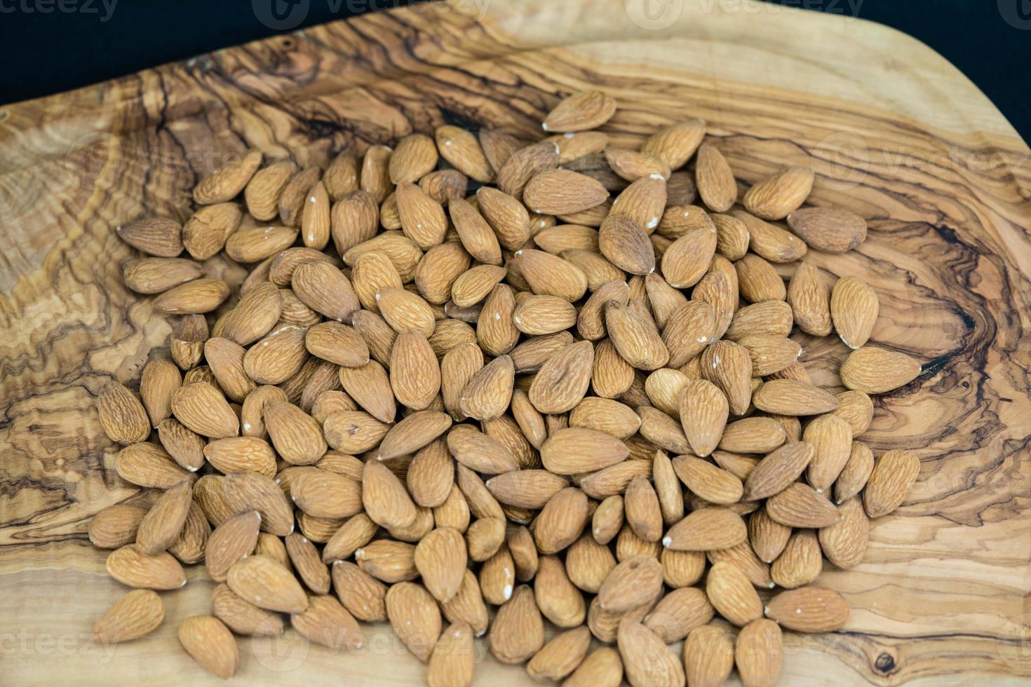 un tas d'amandes décortiquées sur bois d'olivier photo