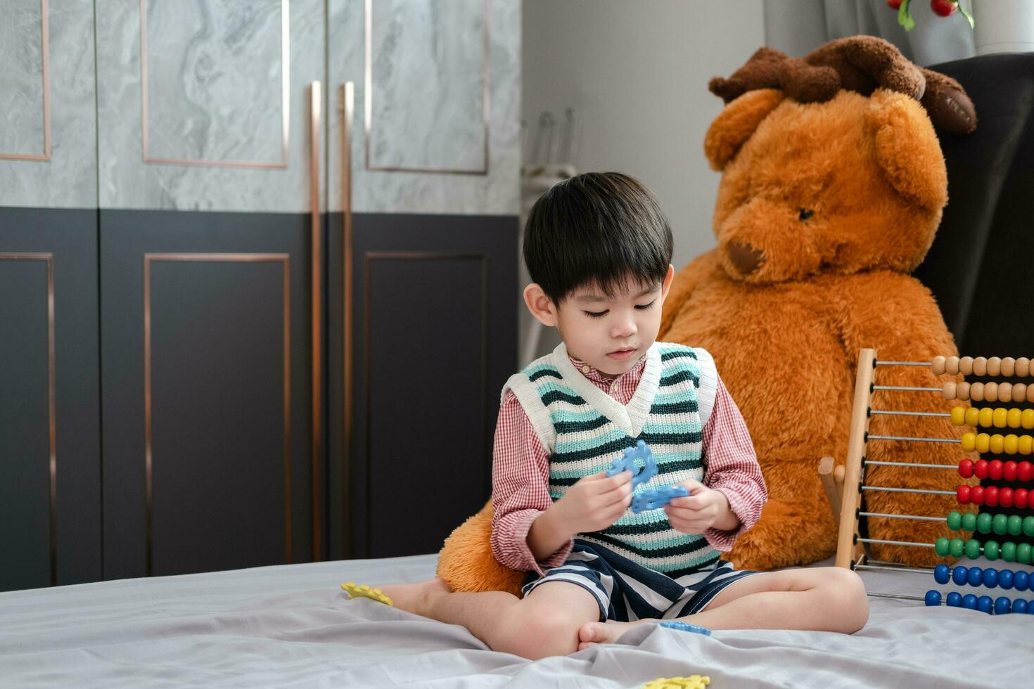 asiatique garçon en jouant avec scie sauteuse puzzles sur le lit joyeusement photo