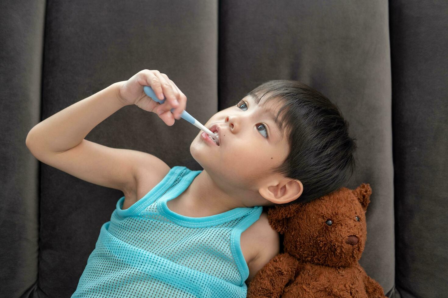asiatique garçon brossage le sien les dents sur le vivant pièce photo