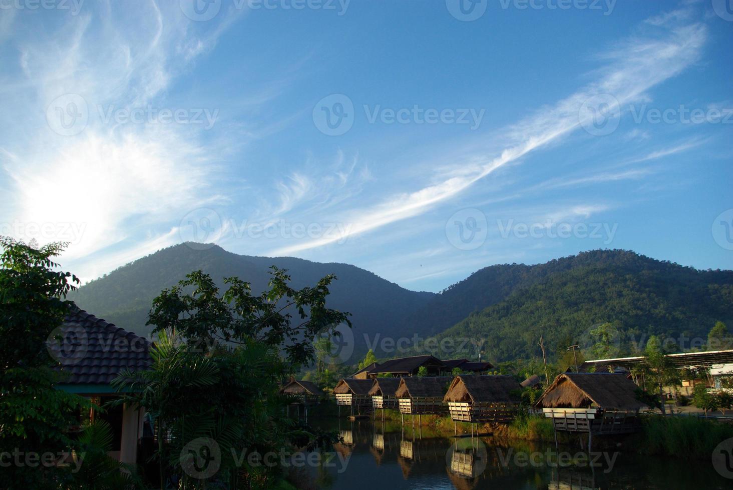 le matin, petites cabanes légères au bord du lac et vue sur la montagne photo