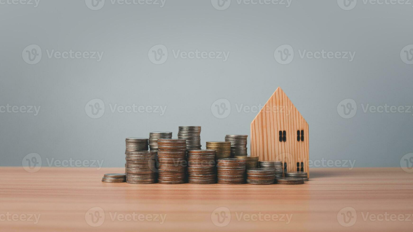 modèle en bois maison et pièces de monnaie doublé en haut sur en bois sol sur blanc Contexte. concepts de finance, des économies et investissement. réel biens concepts. photo