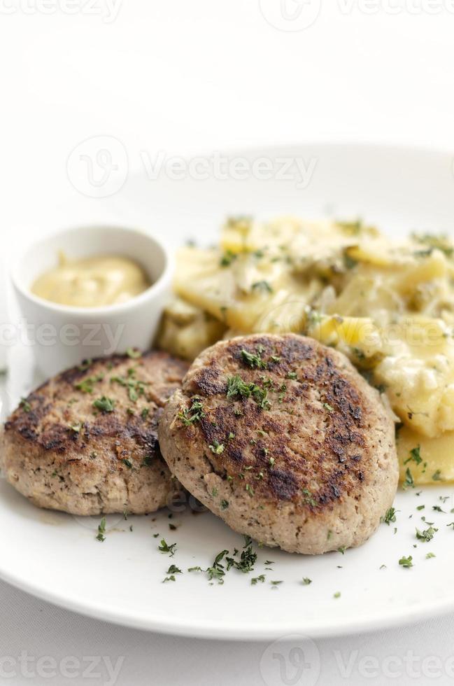boulettes de viande frikadellen allemandes avec pommes de terre frites à l'oignon crémeux et sauce moutarde sur plaque blanche photo