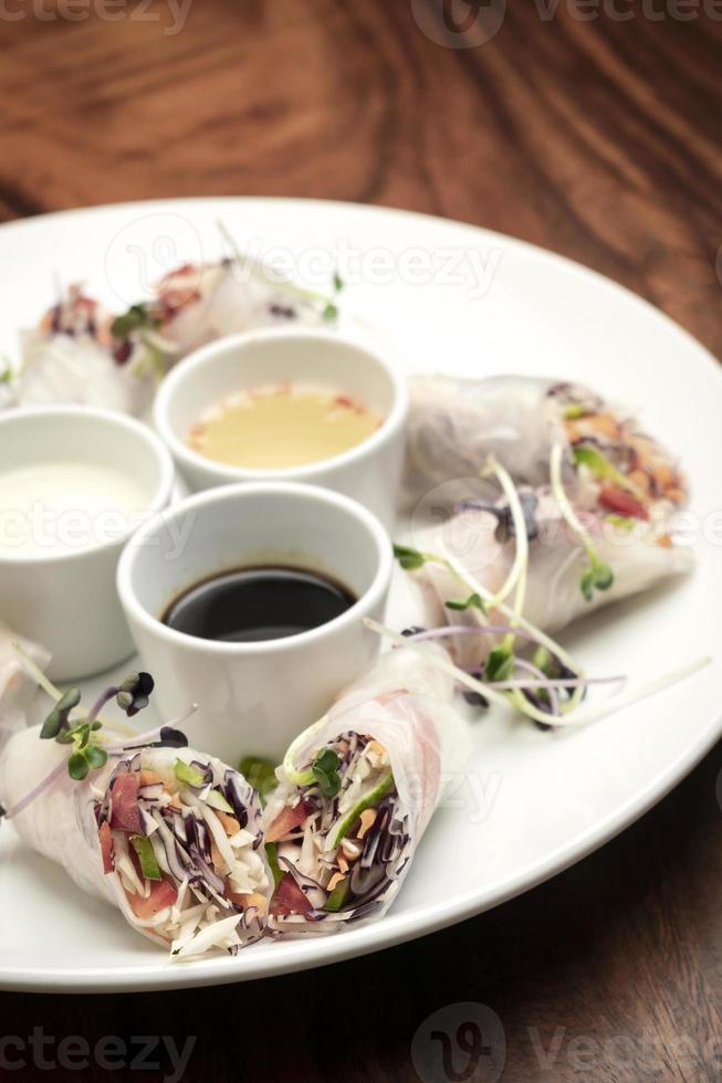 rouleaux de printemps végétaliens aux légumes frais asiatiques avec sauces au vietnam photo