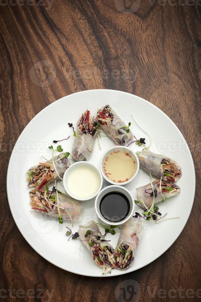 rouleaux de printemps végétaliens aux légumes frais asiatiques avec sauces au vietnam photo