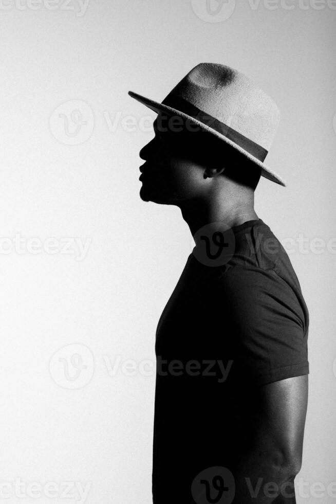 silhouette tête de triste africain américain homme dans chapeau sur noir et blanc isolé Contexte photo
