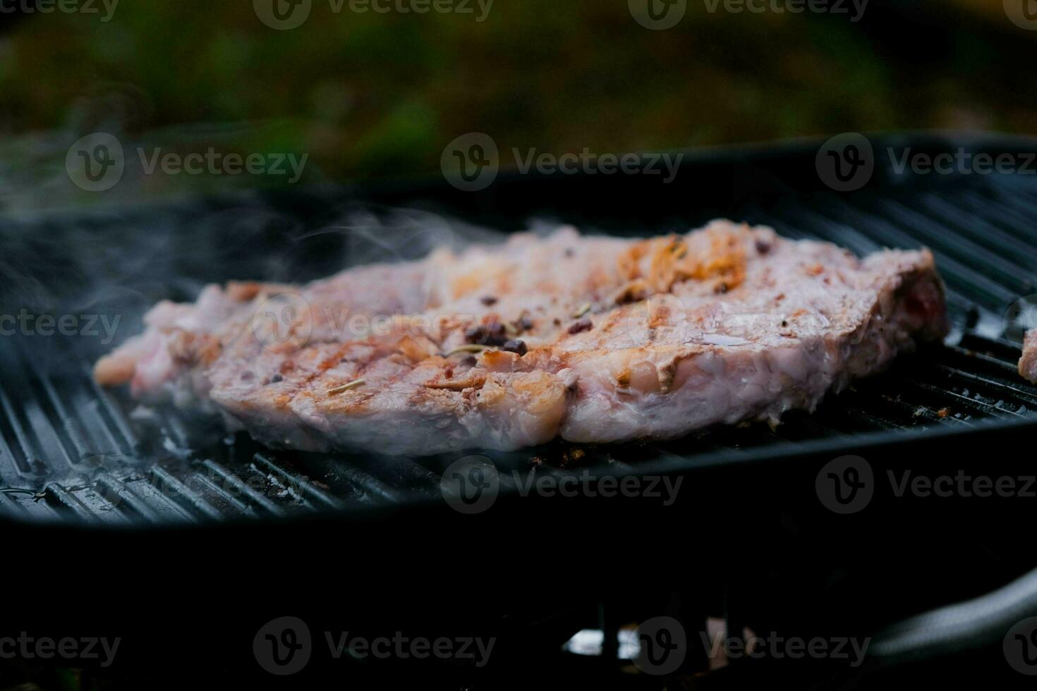 grillé du boeuf steak avec épices sur le gril avec fumée. photo
