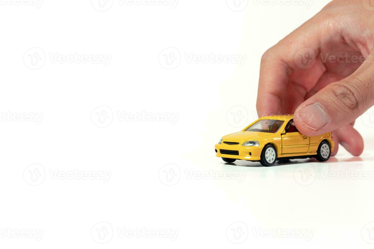 main en portant une Jaune jouet voiture isolé sur blanc Contexte. après certains modifications. photo