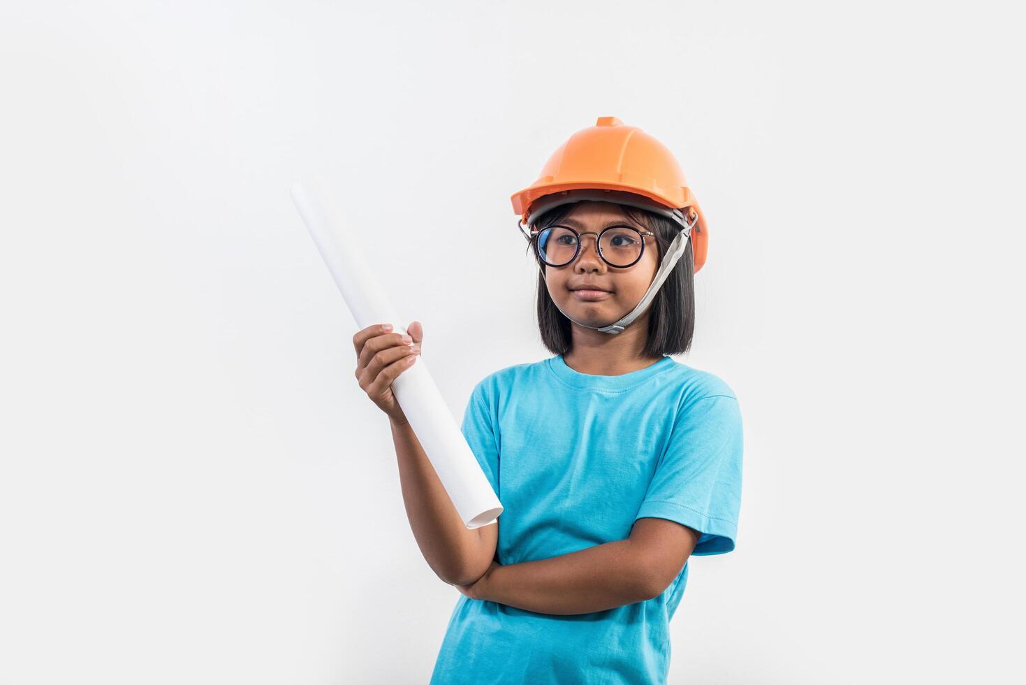 petite fille portant un casque orange en studio shot. photo