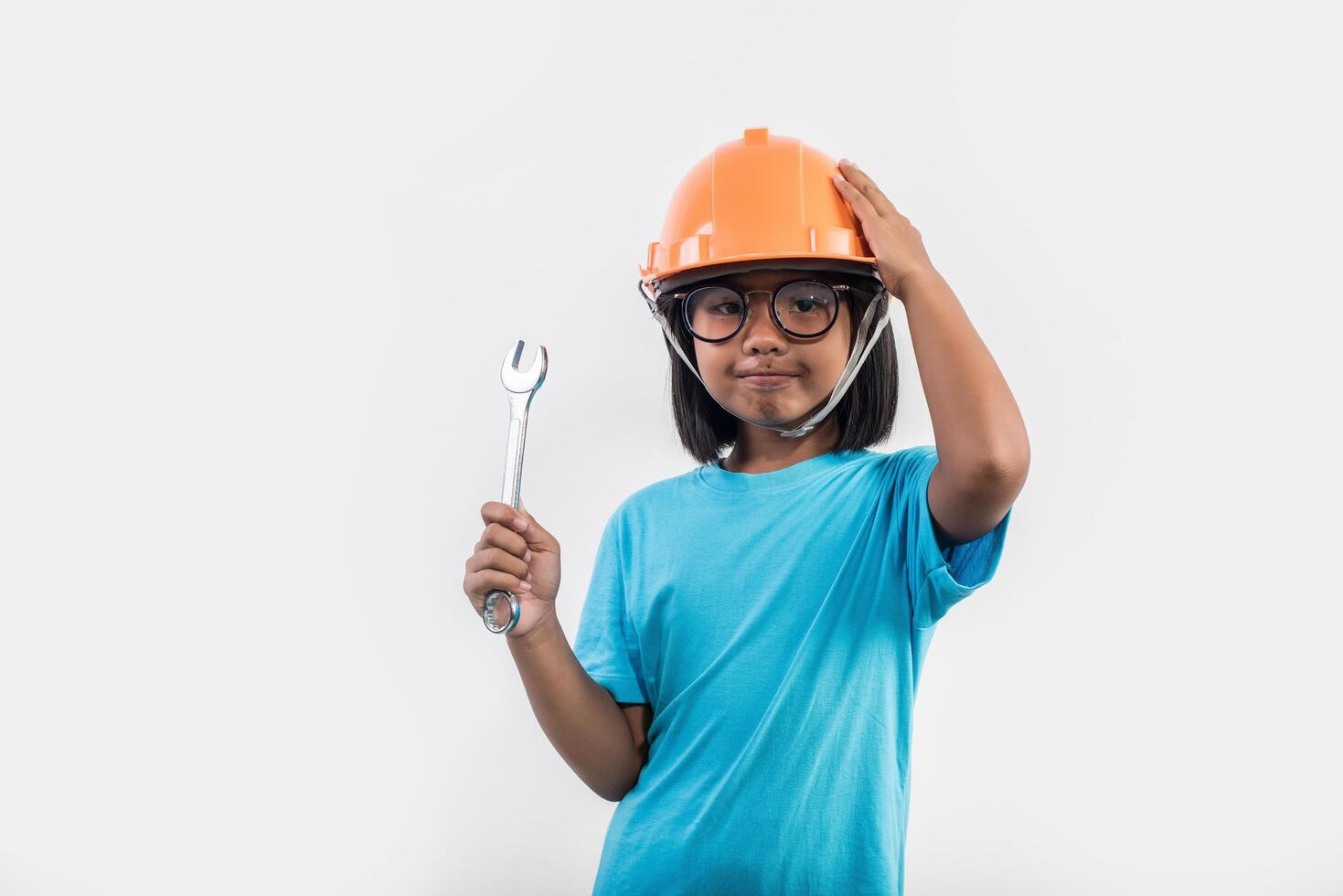 petite fille portant un casque orange en studio shot. photo