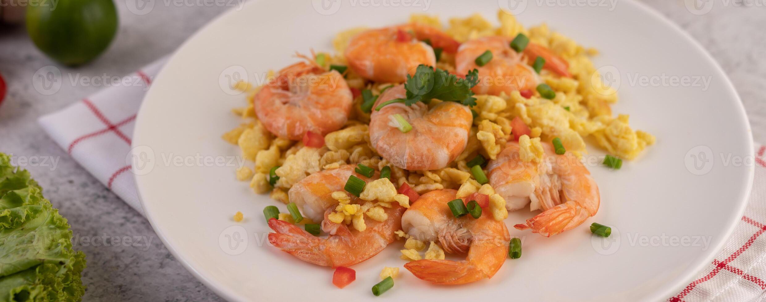 mélanger les œufs frits aux crevettes sur une assiette blanche. photo