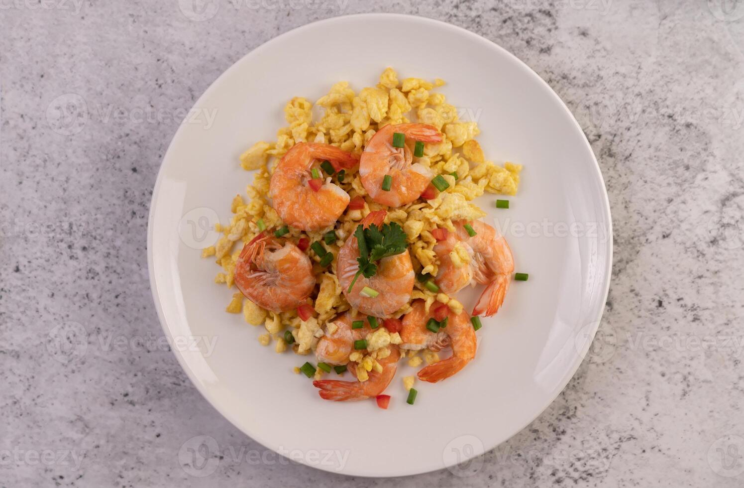 mélanger les œufs frits aux crevettes sur une assiette blanche. photo