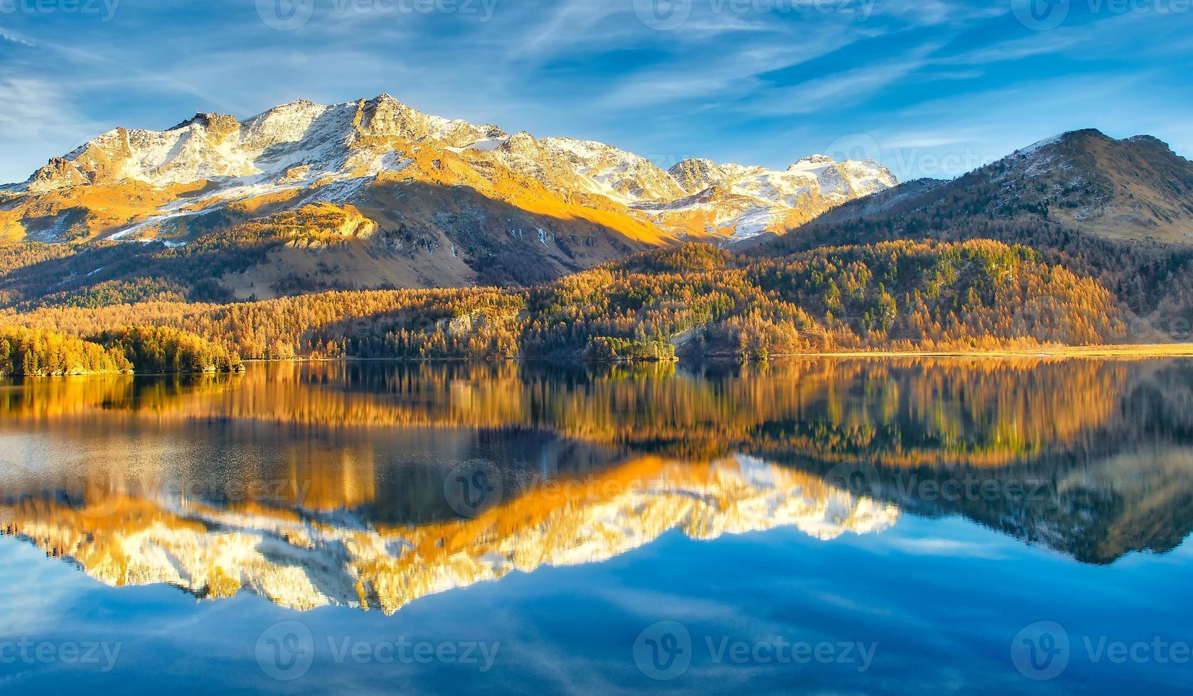 lac alpin à la fin de l'automne avec des reflets de montagnes photo