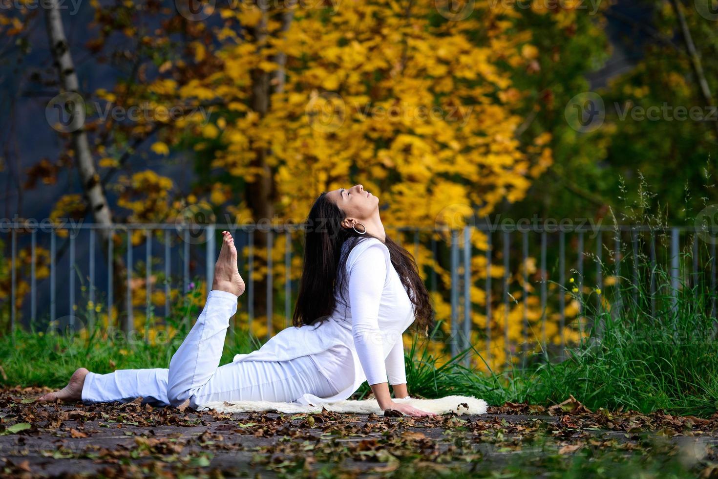 fille en blanc en position de yoga dans le parc photo