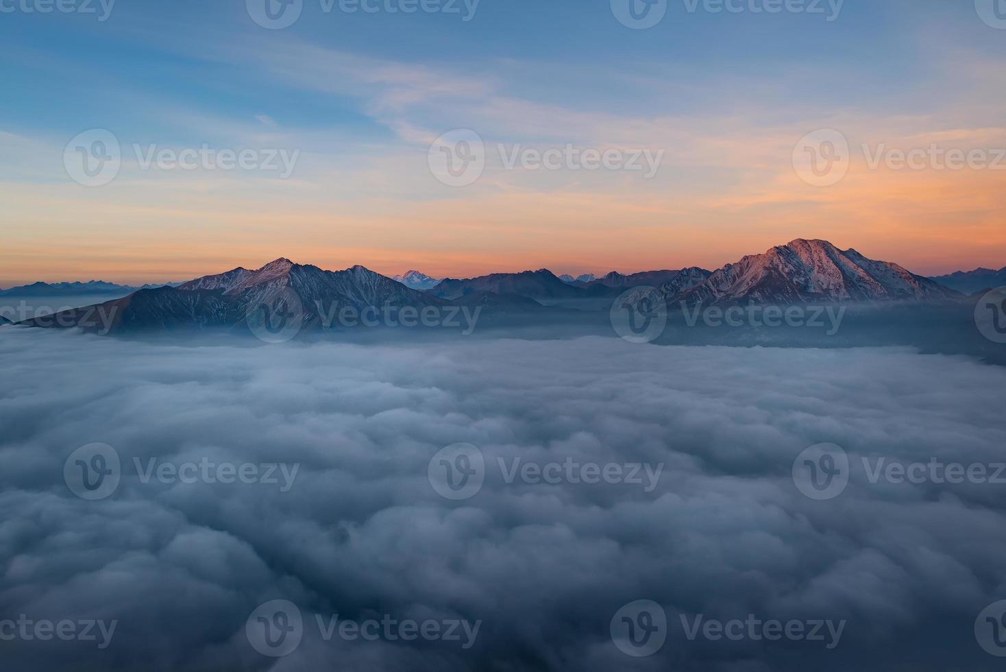 les montagnes jaillissent des nuages bas photo