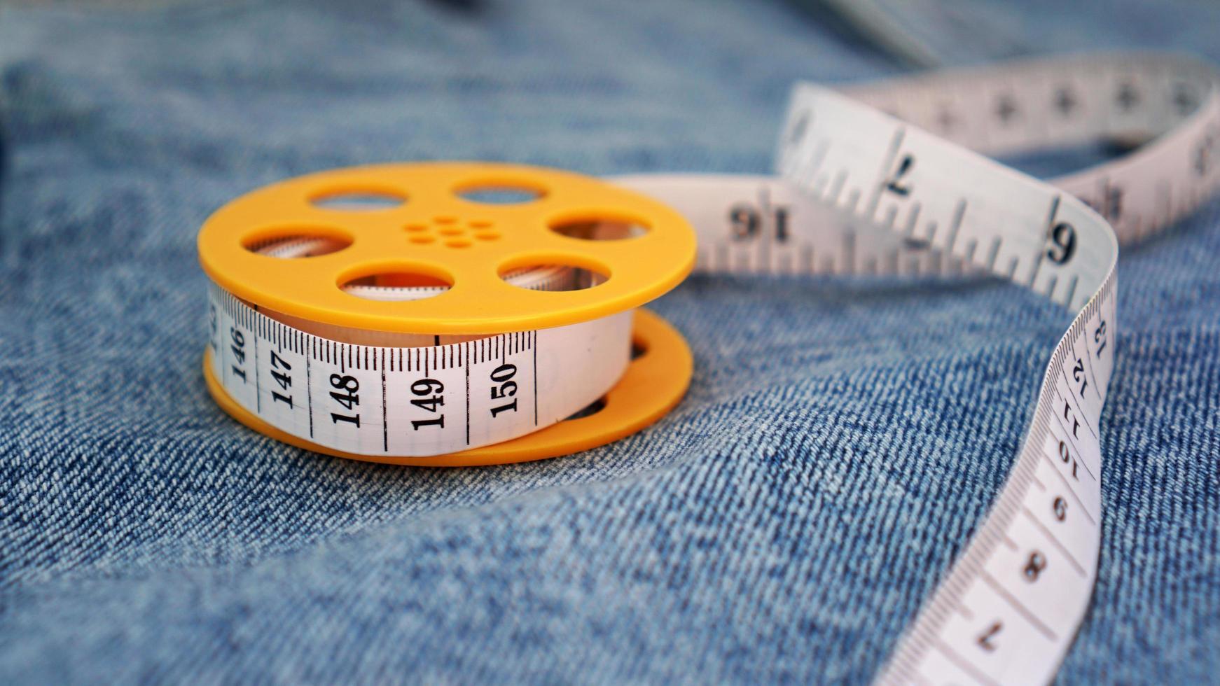 un jean bleu et un ruban à mesurer. concept de denim minceur ou à coudre photo