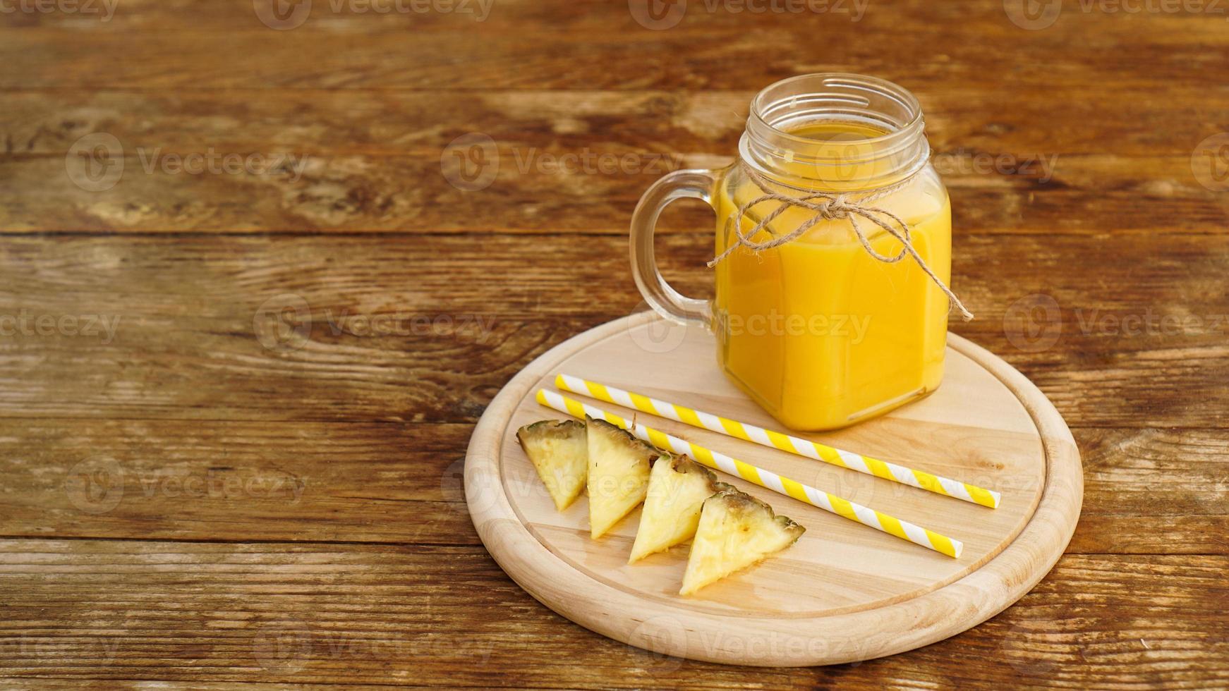 bouteilles de jus d'ananas sur une table en bois. photo