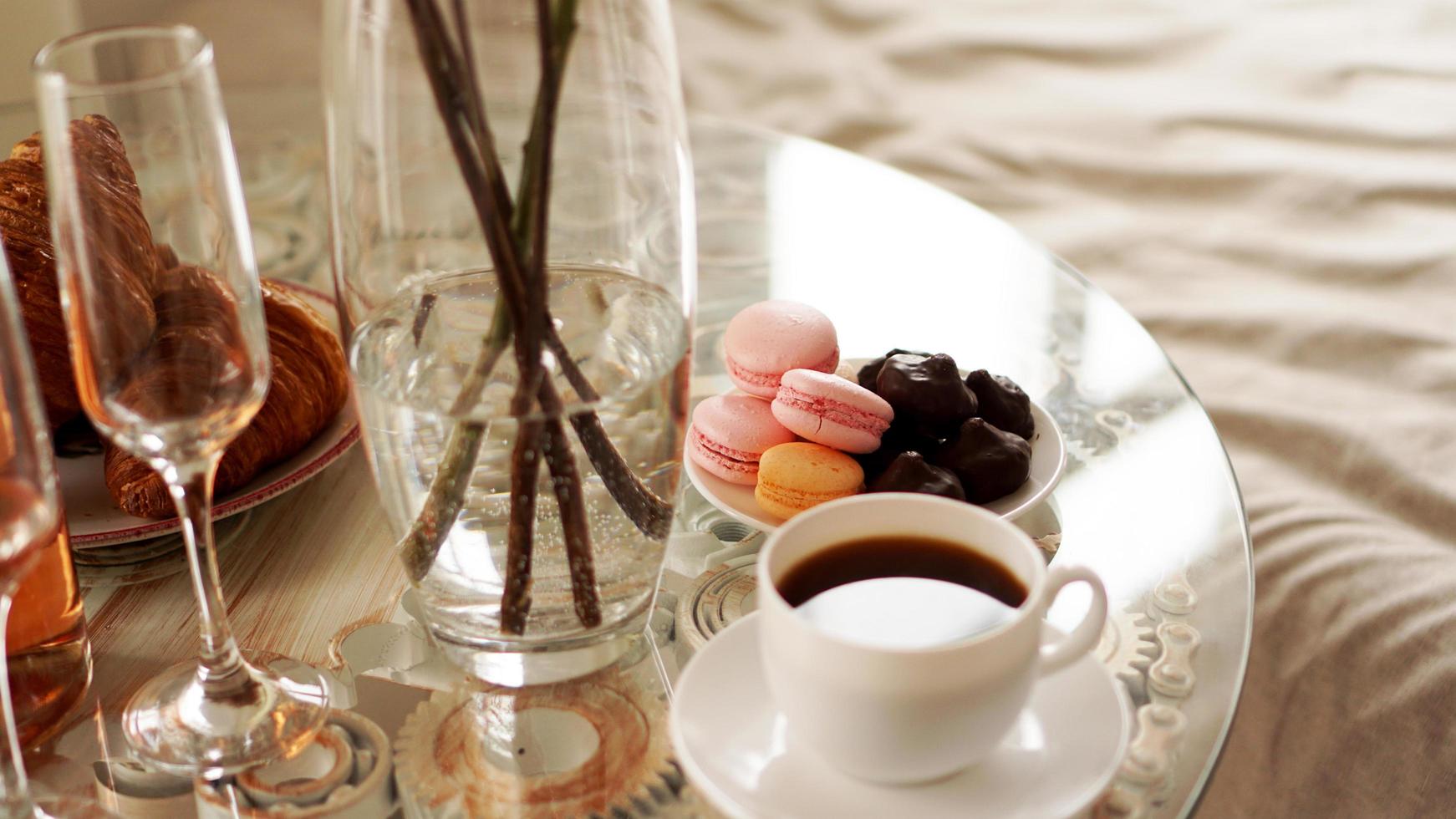 table en verre avec une tasse de café, macarons sucrés. photo