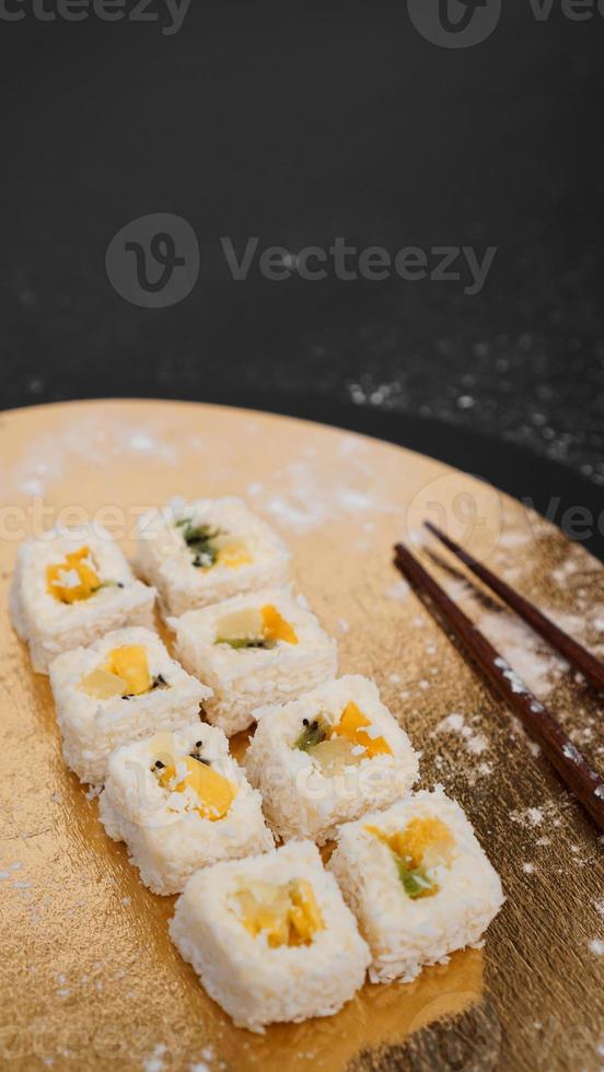 livraison de sushis. petits pains sucrés à base de riz, d'ananas, de kiwi et de mangue. photo