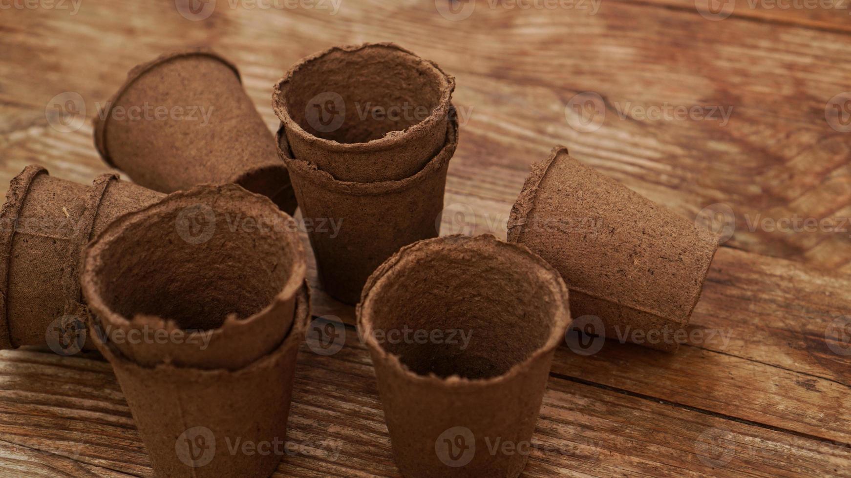 pots de tourbe vides pour les semis sur un fond en bois. jardinage photo