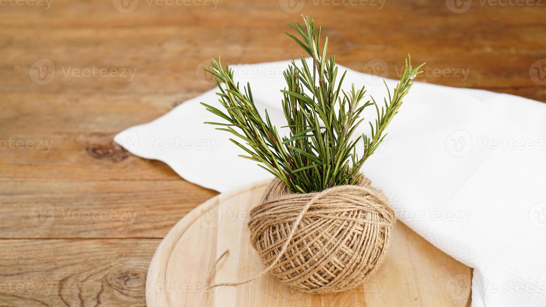 brins de romarin et écheveaux de corde de jute sur un bois photo