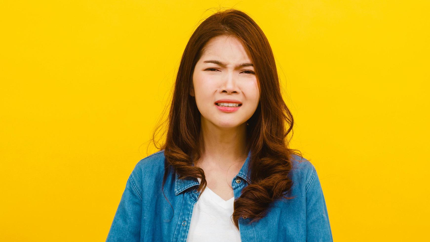 femme asiatique avec une expression négative sur fond jaune. photo