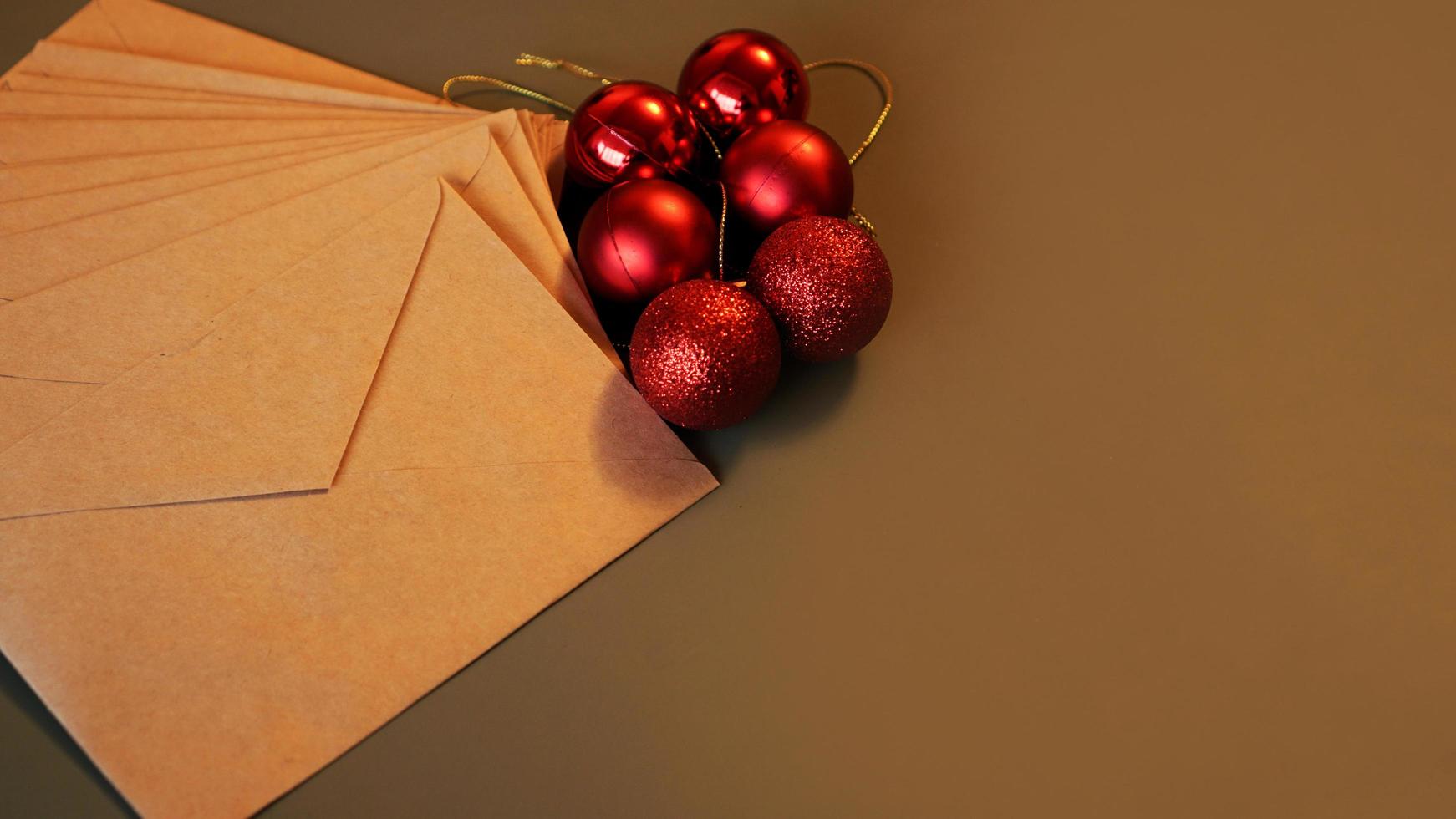 composition de noël. enveloppes artisanales et boules rouges photo