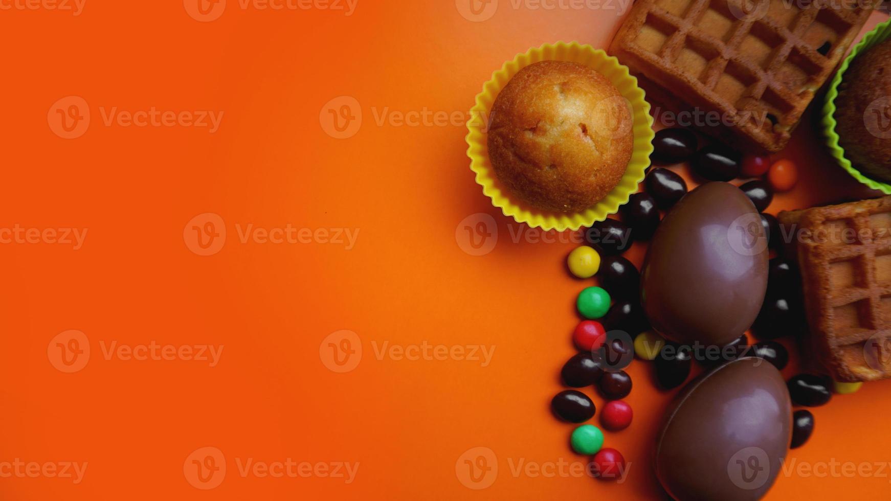 délicieux oeufs de pâques au chocolat, bonbons sur fond orange photo