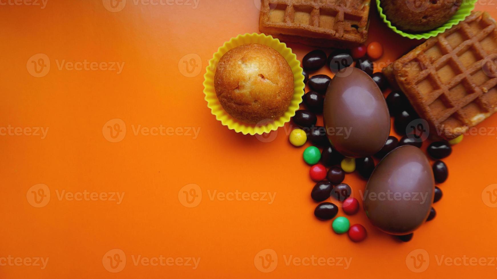 délicieux oeufs de pâques au chocolat, bonbons sur fond orange photo