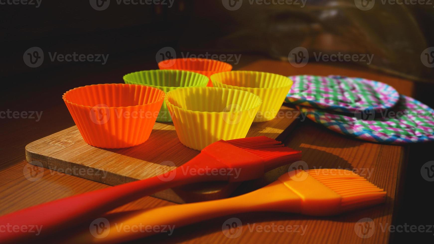 brosse en silicone et doublures de cupcakes sur table en bois photo