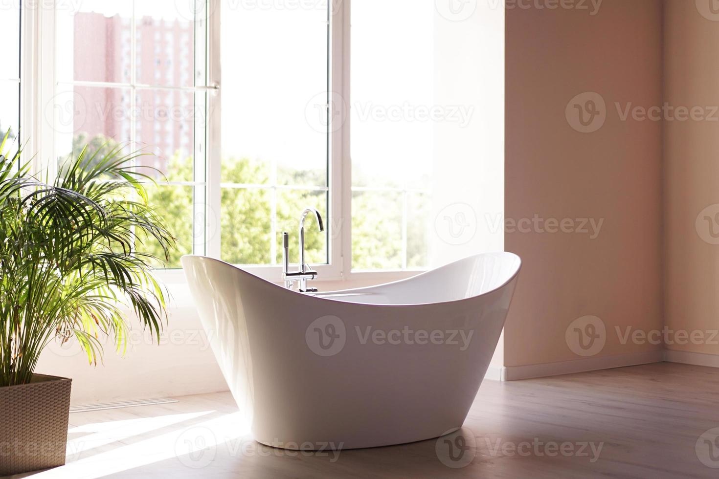 salle de bain moderne. bain blanc avec des branches de palmiers verts photo