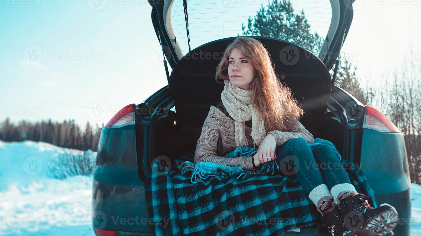 fille heureuse assise sur un camion de voiture dans la forêt d'hiver photo