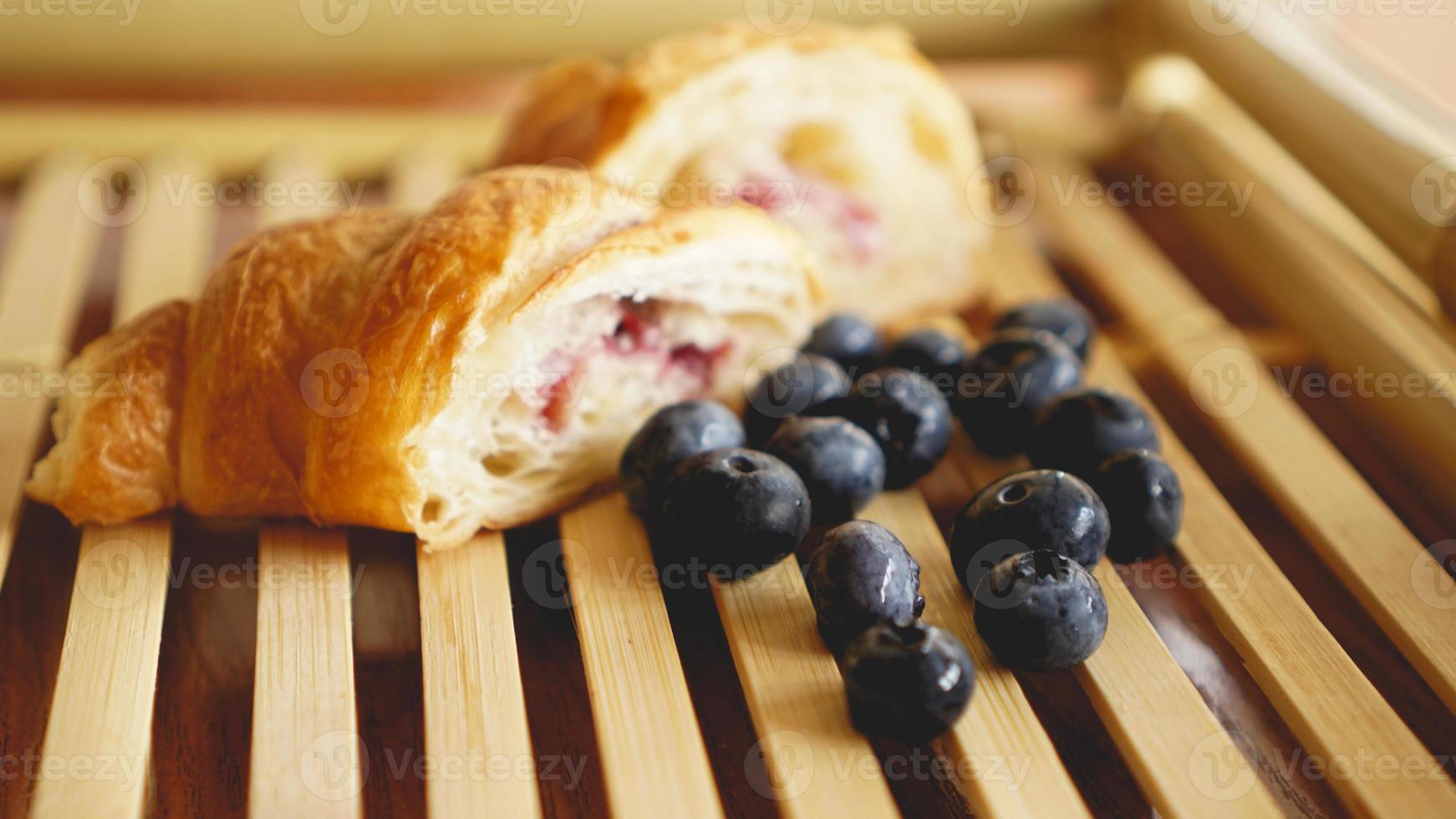 délicieux petit déjeuner avec croissant et myrtille sur fond de bois photo