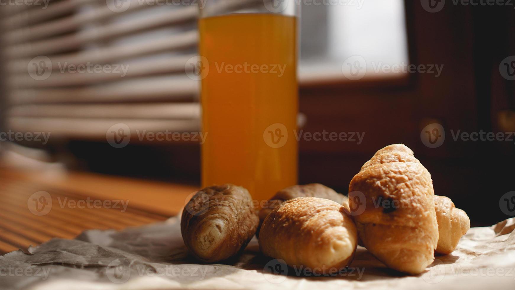 croissants fraîchement cuits au jus d'orange sur papier kraft photo