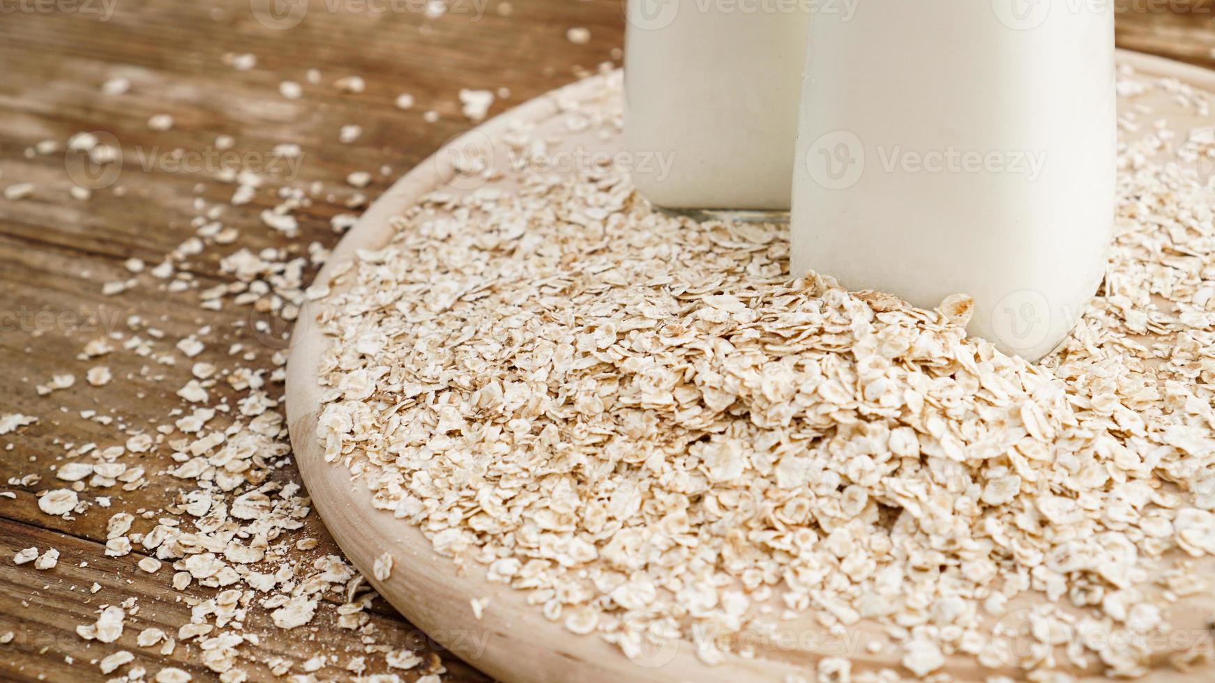 flocons d'avoine et bouteille de lait frais sur une planche en bois photo