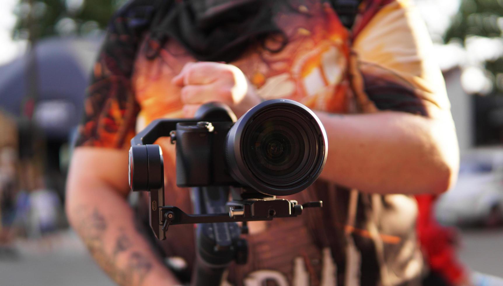 un homme avec un appareil photo et un objectif. photocaméra pour la prise de vue vidéo.