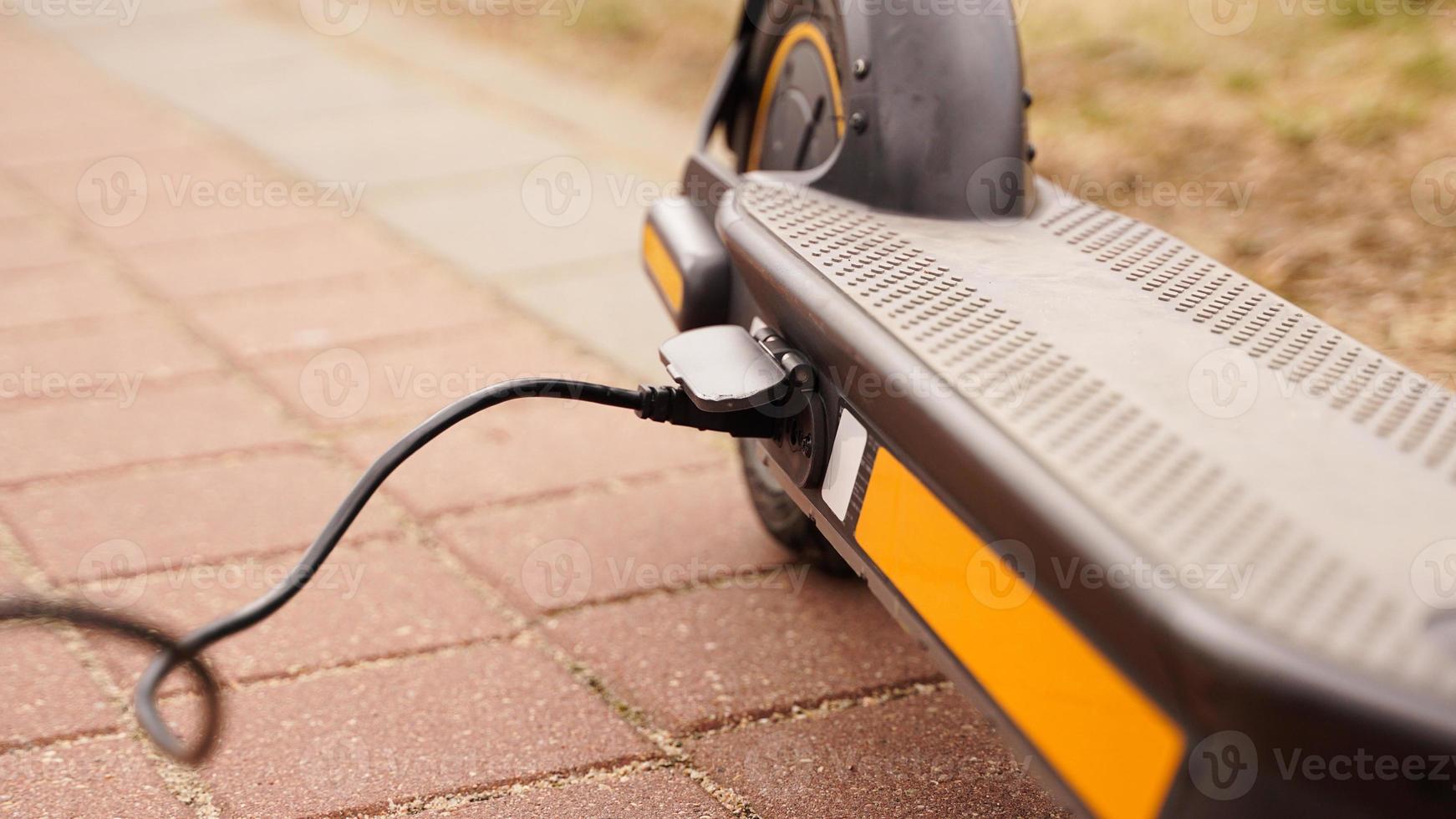 le scooter électrique se recharge à l'extérieur. photo