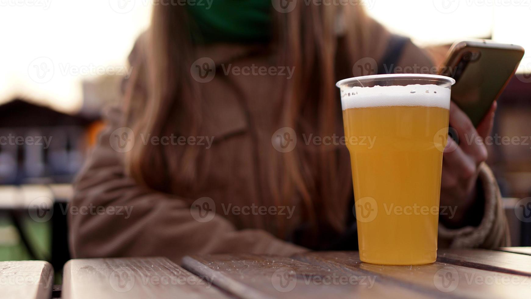 bière légère dans un verre en plastique. fille buvant de la bière à l'aire de restauration photo