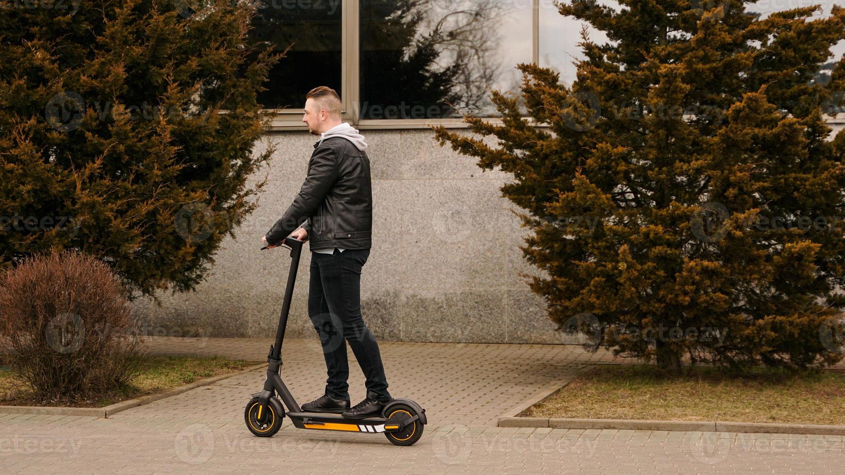 homme moderne équitation scooter électrique dans la ville photo