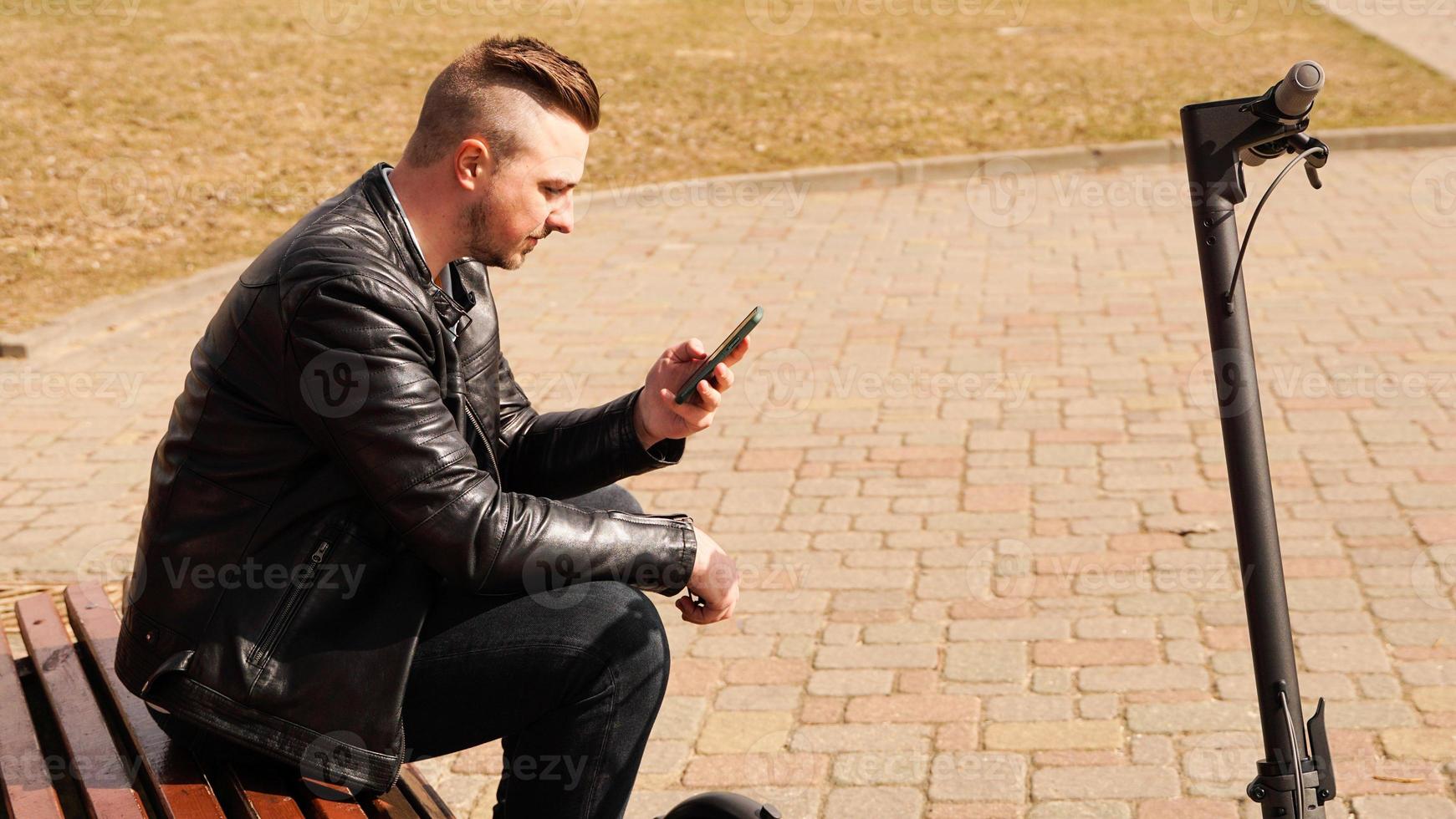 jeune homme est assis sur un banc un jour de printemps photo