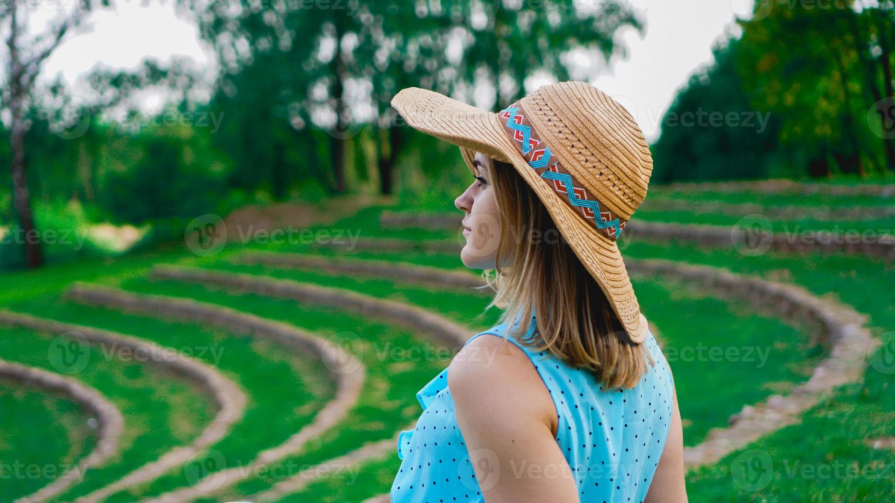 Jeune femme au chapeau de paille dans le jardin ensoleillé photo