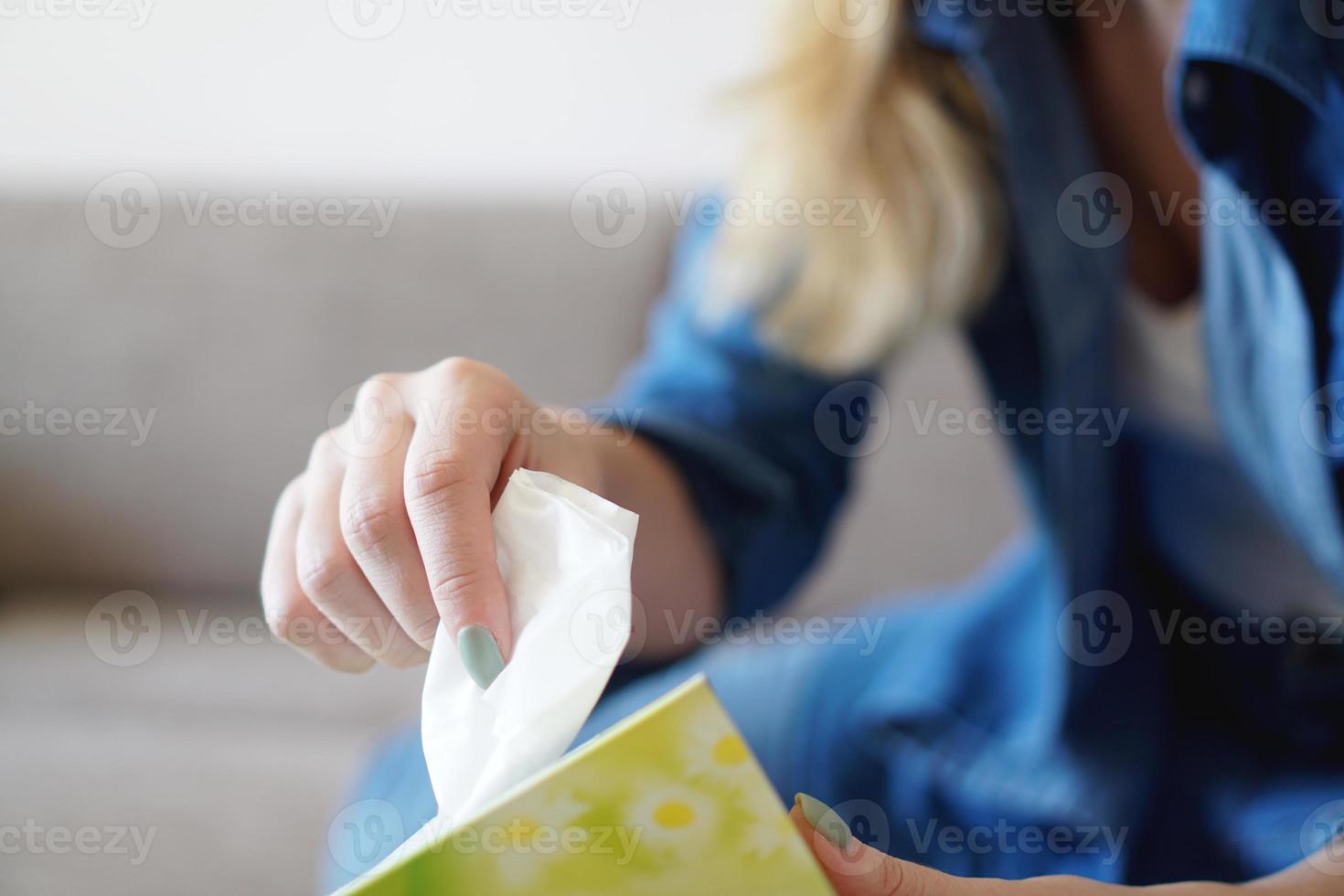 femme prenant un mouchoir en papier du porte-serviettes sur la table photo
