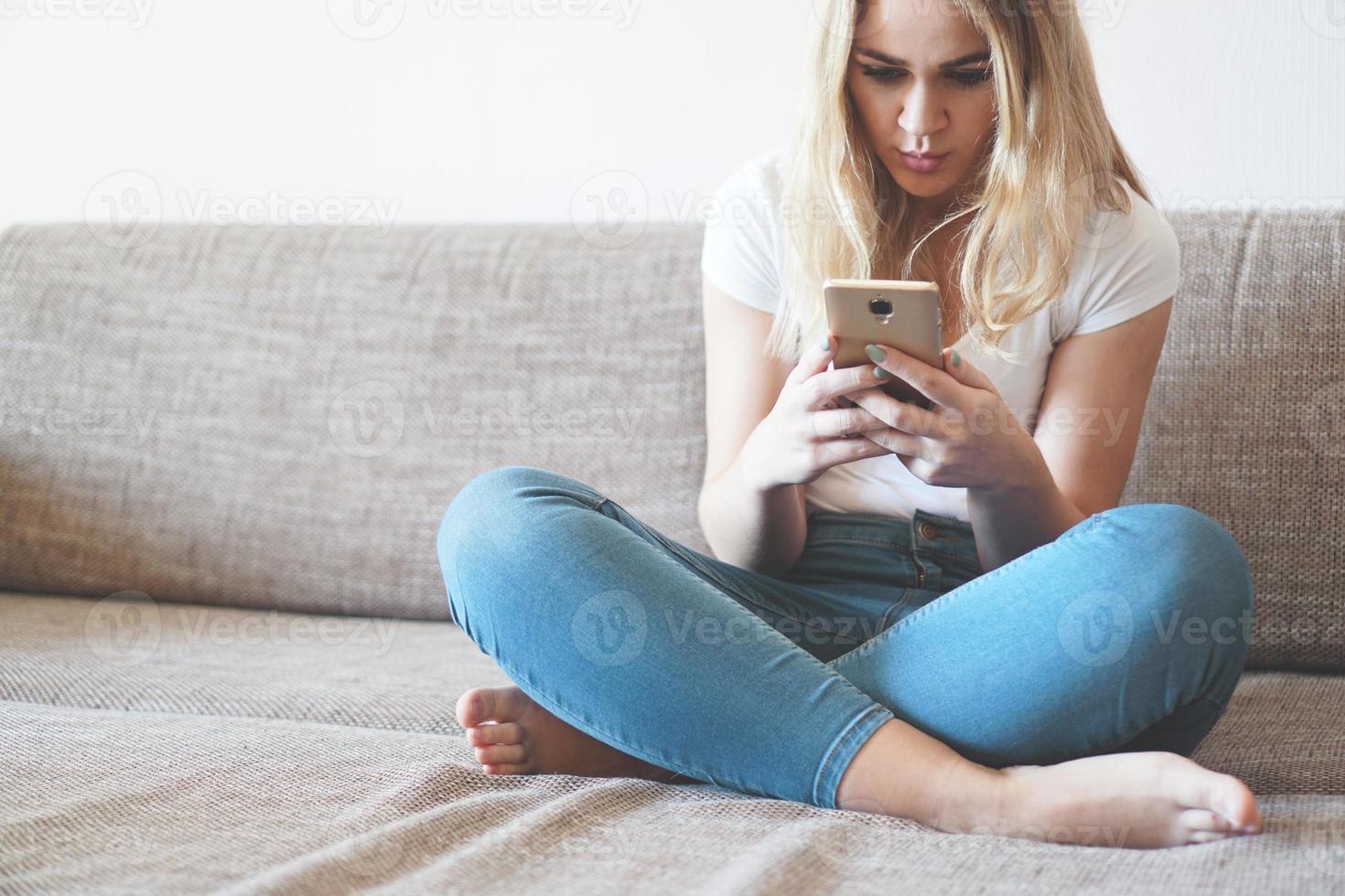 jolie jeune femme se détendre sur un canapé à la maison photo