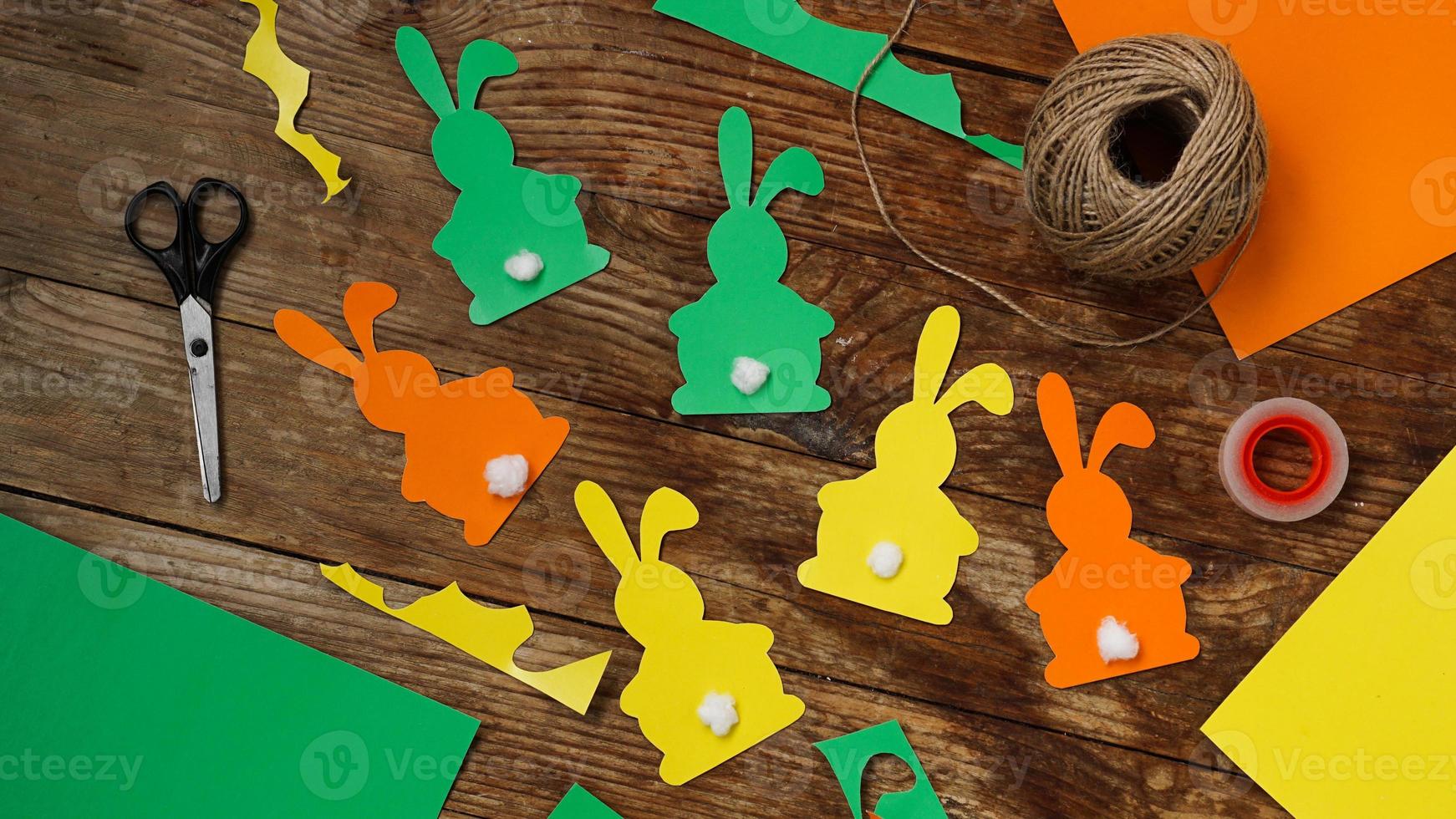 lapins de pâques en papier sur un fond en bois. créer un décor photo