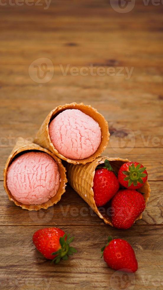 glace à la fraise dans un cornet gaufré. fruits rouges et boules de glace photo