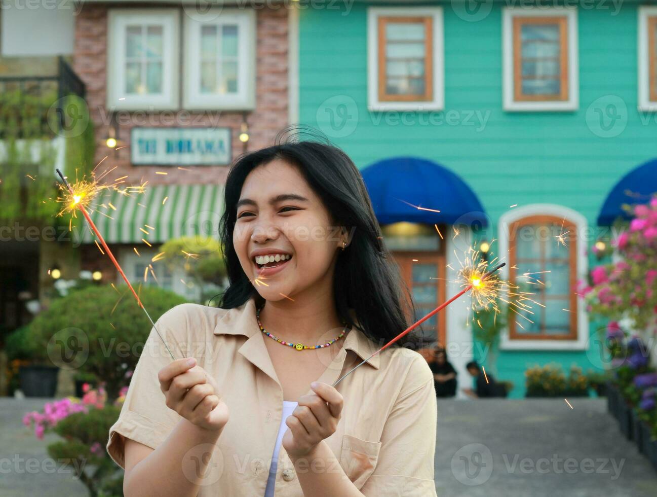 content Jeune asiatique femme en portant cierge magique célébrer Nouveau année veille dans ancien maison cour, Extérieur jardin photo