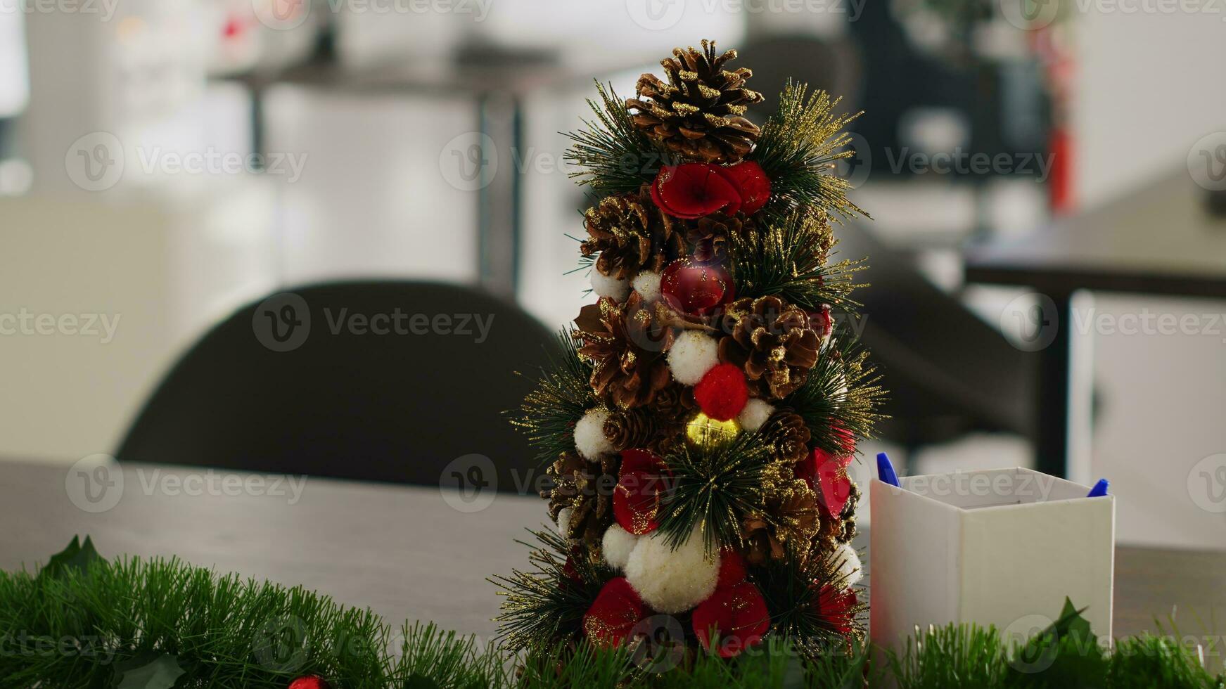 proche en haut coup sur miniature Noël pin arbre décoration mis dans vide Commencez bureau, avec floue Contexte de de fête lieu de travail rempli avec Noël lumières, guirlandes et couronnes de fleurs photo