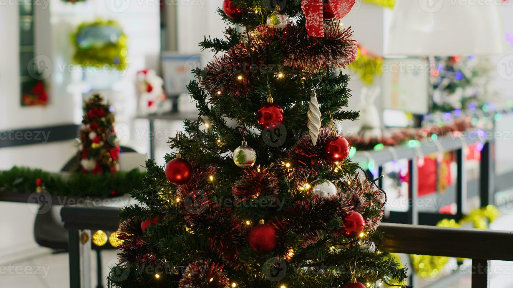 proche en haut coup de Noël pin arbre orner avec guirlandes et babioles dans vide bureau, avec floue Contexte de affaires graphiques sur ordinateur écrans dans Noël orner lieu de travail pendant hiver vacances saison photo