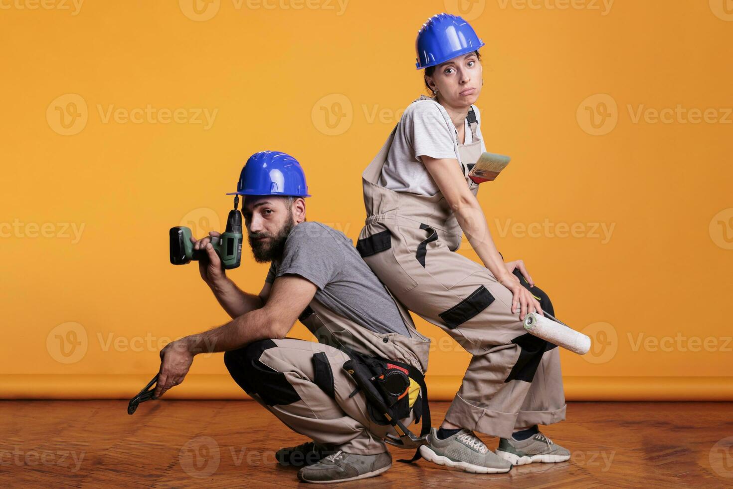 intérieur constructeurs agissant sur de soi avec bâtiment outils, posant sur studio Contexte avec construction instruments. en portant Puissance percer pistolet, paire de pinces et La peinture brosses. photo