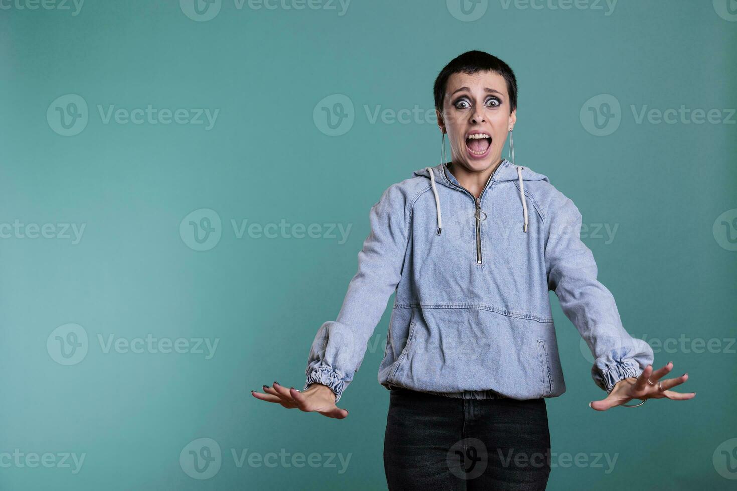 peur terrifié femme ayant effrayé expression après audition le mal nouvelles, nerveux la personne permanent dans studio posant plus de isolé Contexte. effrayé femelle à la recherche à caméra avec choc réaction photo