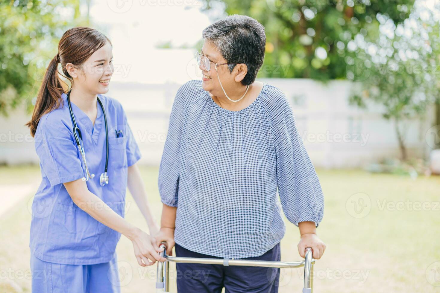 Jeune infirmière portion asiatique Sénior femme marche. soignant assistant vieux Dame patient à allaitement maison. aîné marcher avec marcheur à Accueil se soucier. photo